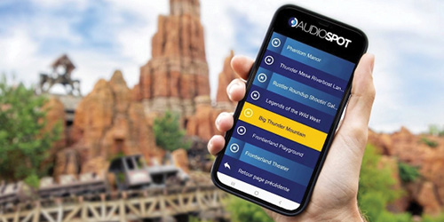 Mobile showing app with Disneyland in background